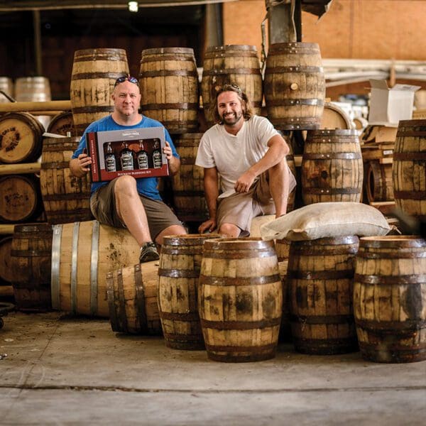 Cam and Aaron sitting on bourbon barrels Timber Creek