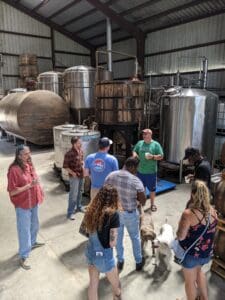 distillery tour with production equipment in background. dogs begging for attention.